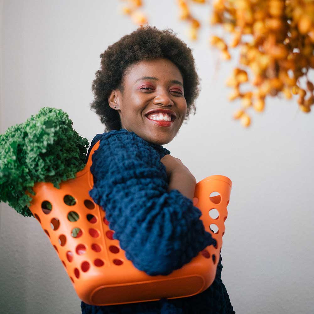 Woman smiling with a basket of vegetables